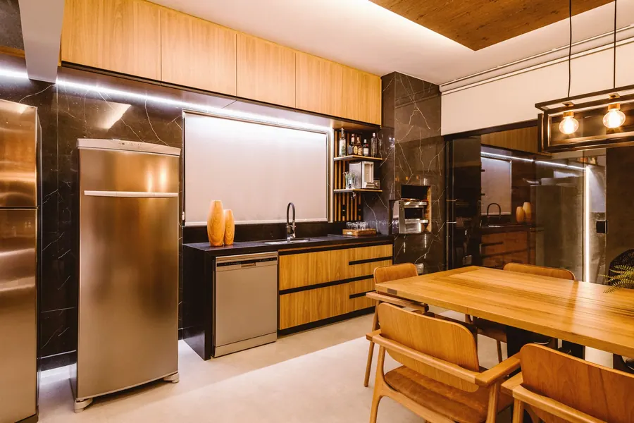 Cozinha com armários de madeira e bancada preta