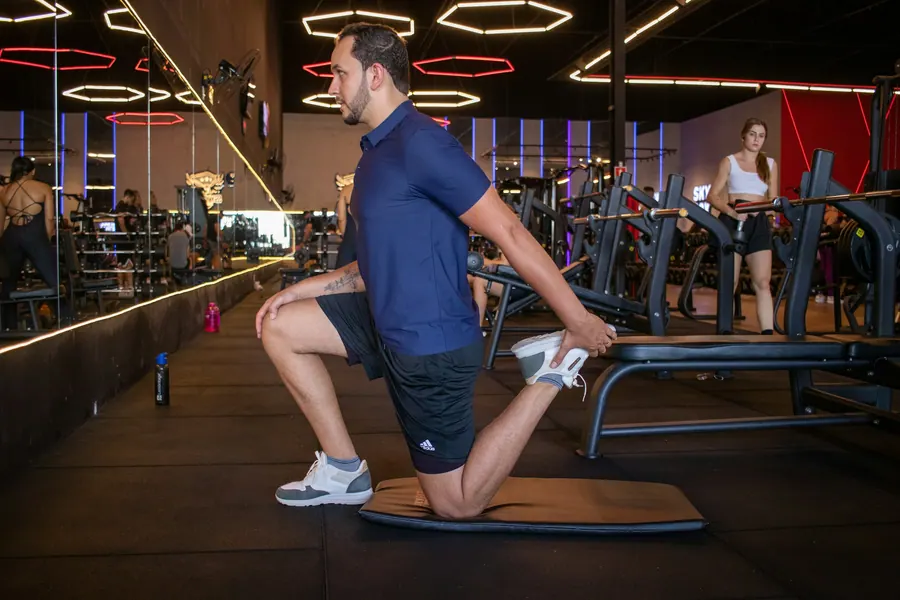 Rafael fazendo um alongamento no tatame da academia