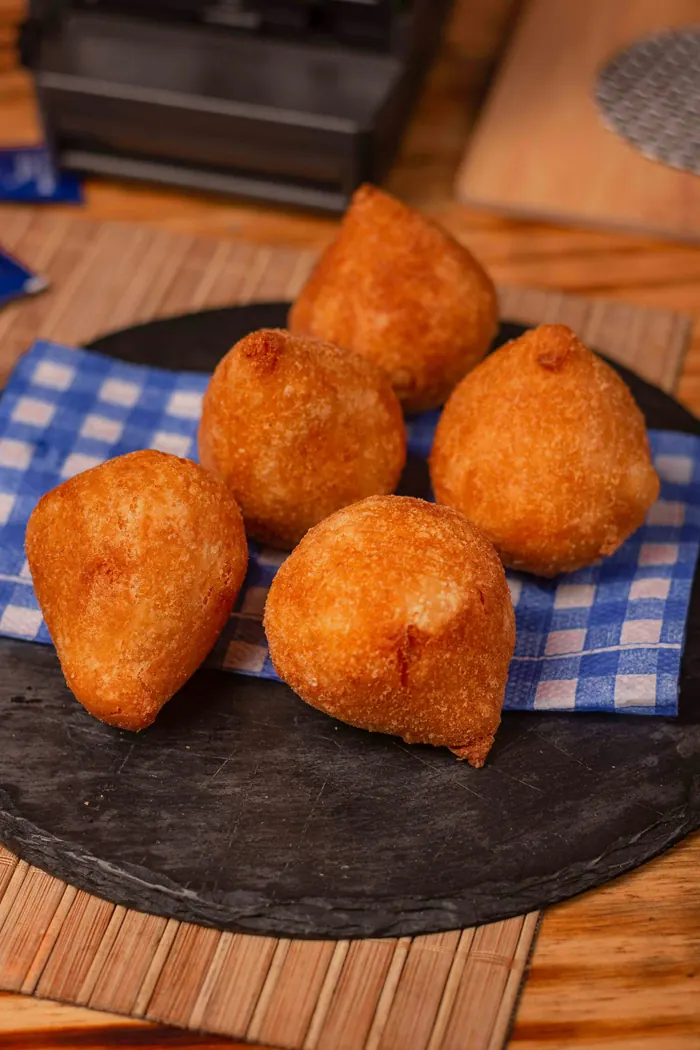 Coxinhas douradas sobre uma pedra de ardósia